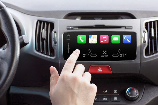 man sitting in a car and touch play finger in a auto smart system