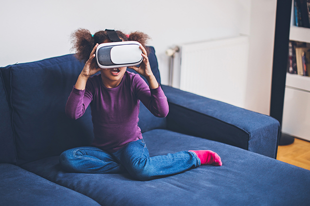 Cool millennial child exploring space with virtual reality glasses